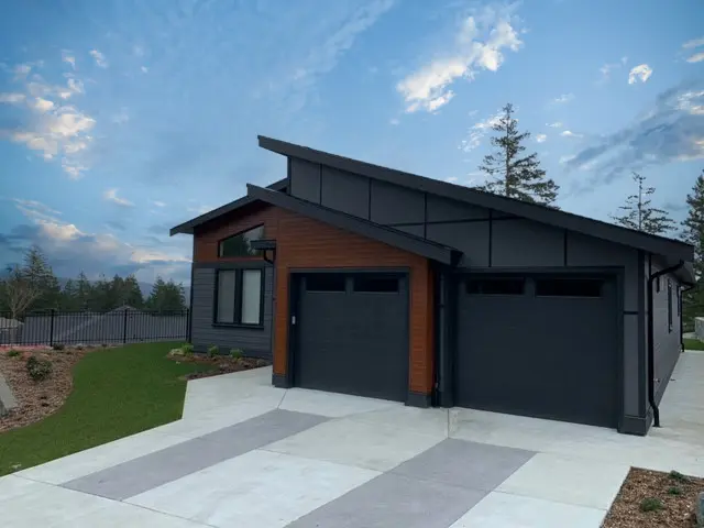 An angular single family home with a garage. There is black anodized EasyTrim and dark cherry FastPlank cladding.